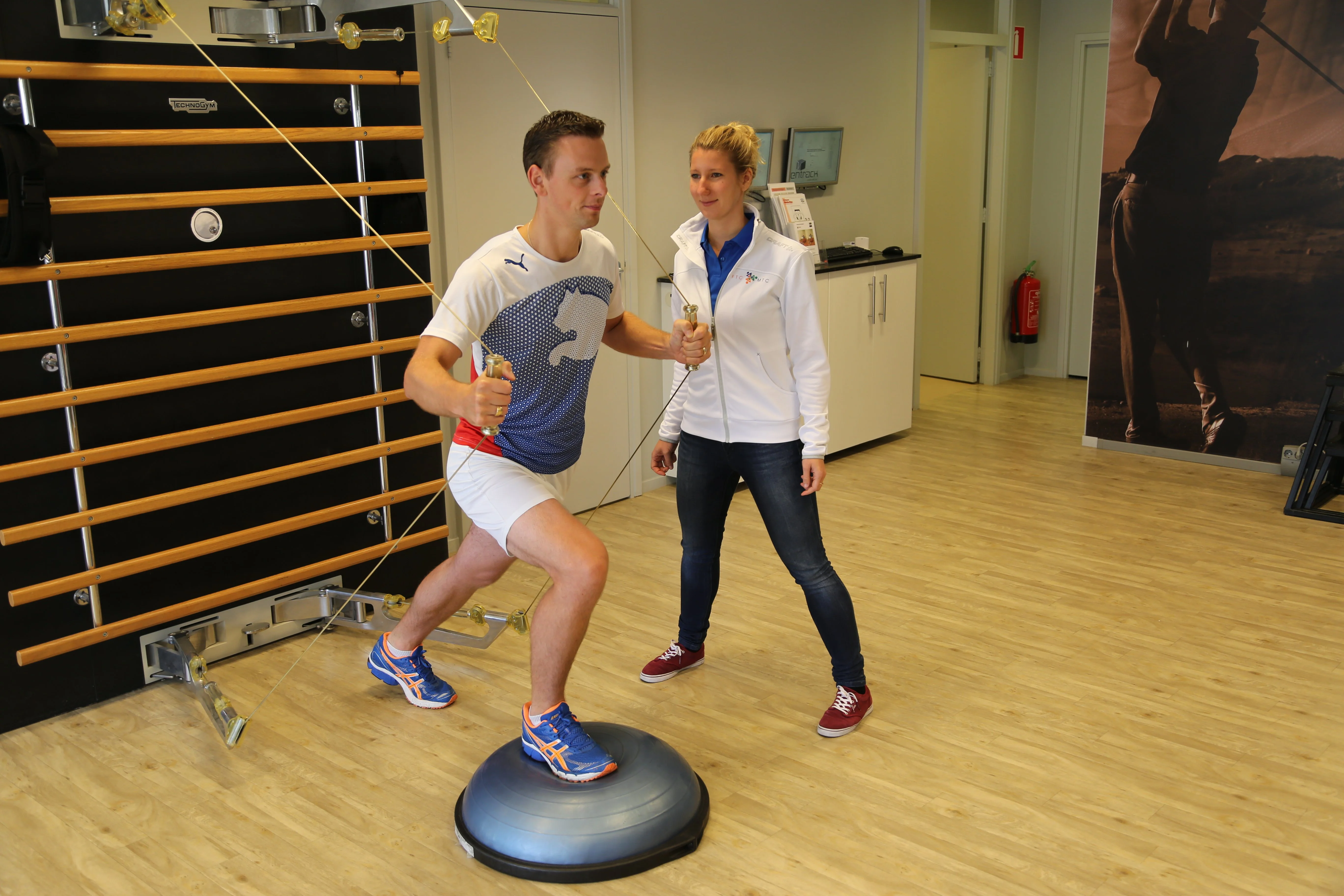 Cliënt voert oefening uit tijdens medische fitness onder begeleiding van fysiotherapeut