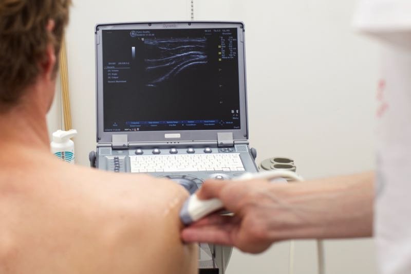 Een man wordt middels echografie nagegaan op de oorzaak van zijn schouderklachten.