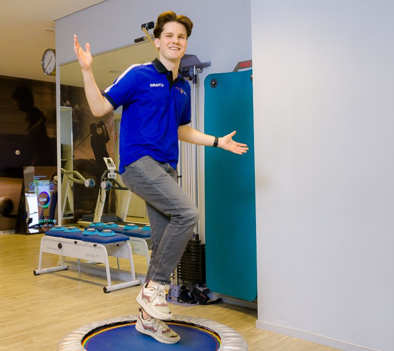 Yasin Sahin oefent balans op een kleine trampoline