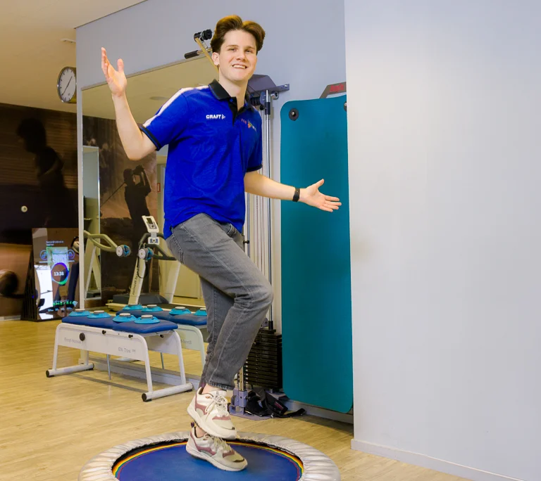 Yasin Sahin oefent balans op een kleine trampoline